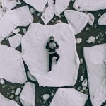 man lying on white rock during daytime