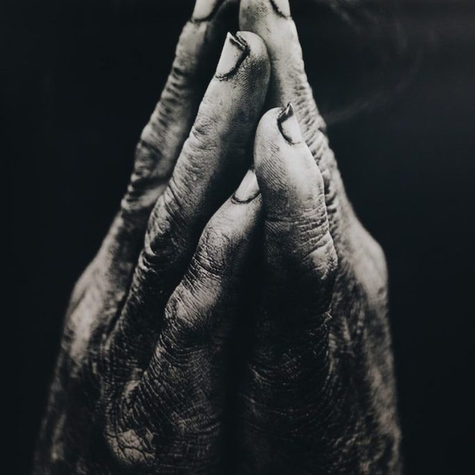 grayscale photography of praying hands
